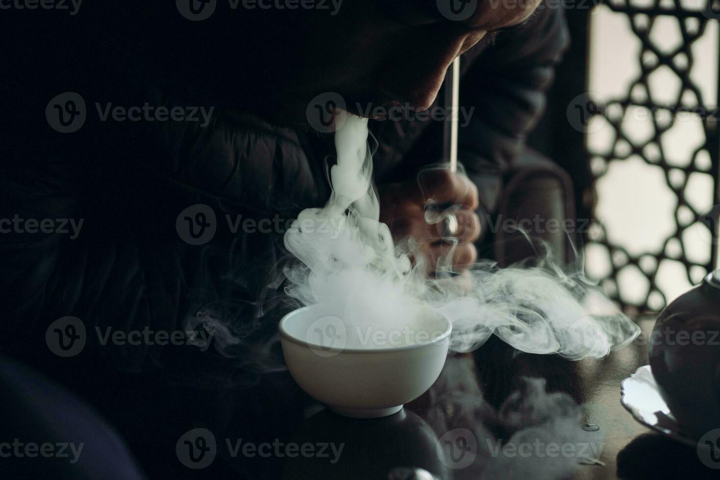 uma cara fuma narguilé dentro shisha Barra foto