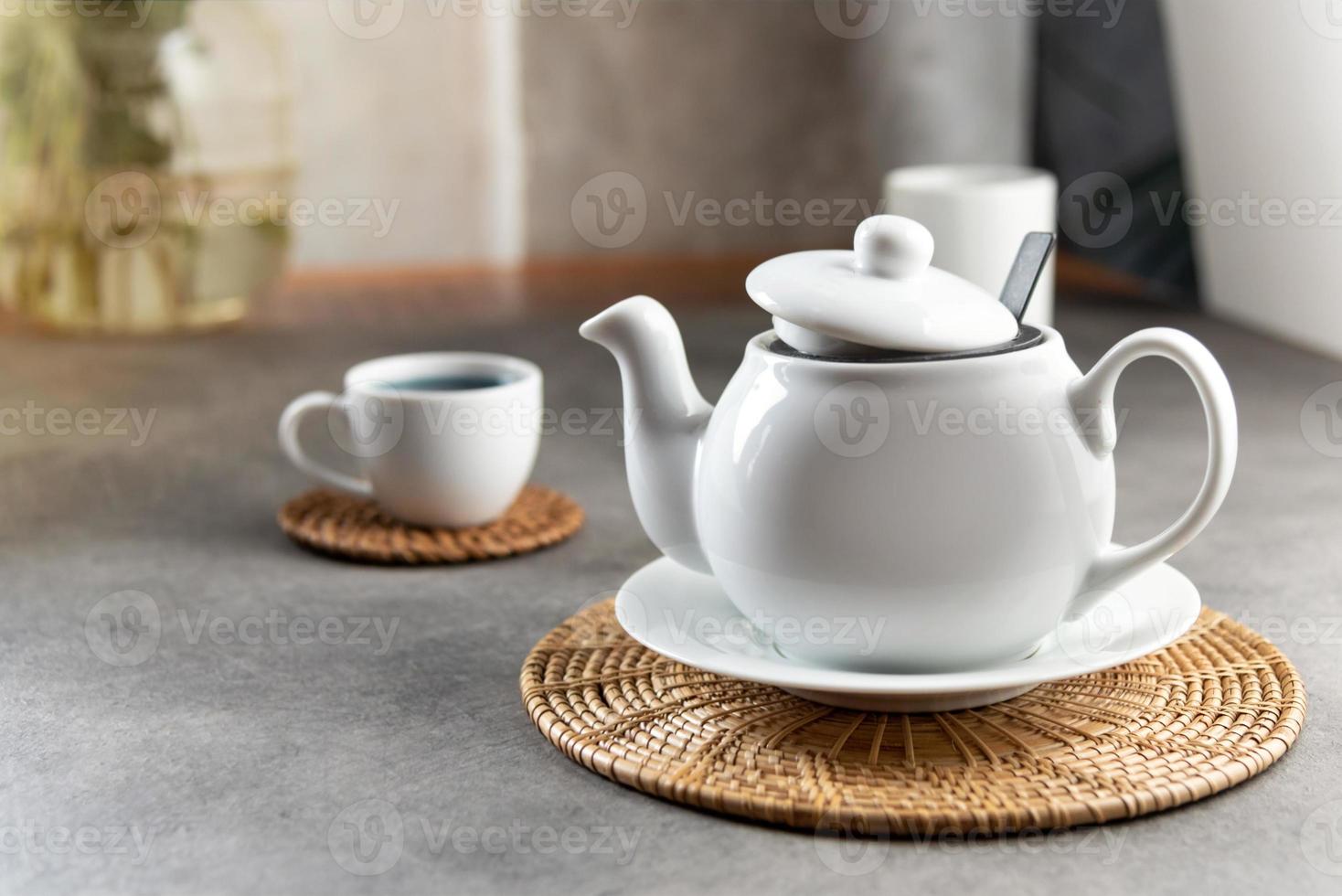 xícara de chá de porcelana branca e bule, configuração de mesa de chá da tarde foto