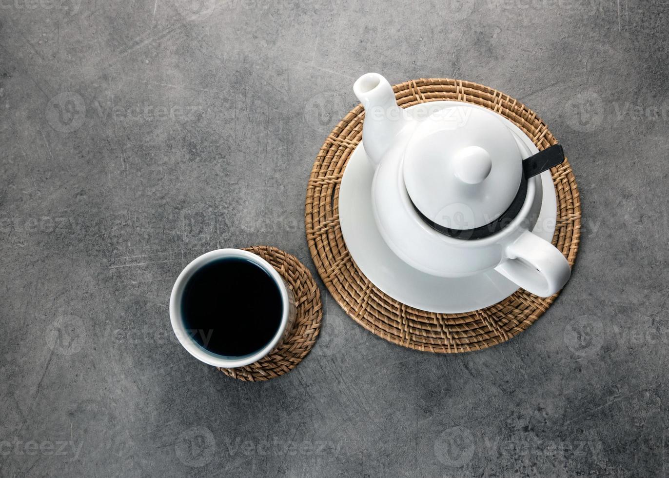 xícara de chá de porcelana branca e bule, configuração de mesa de chá da tarde foto