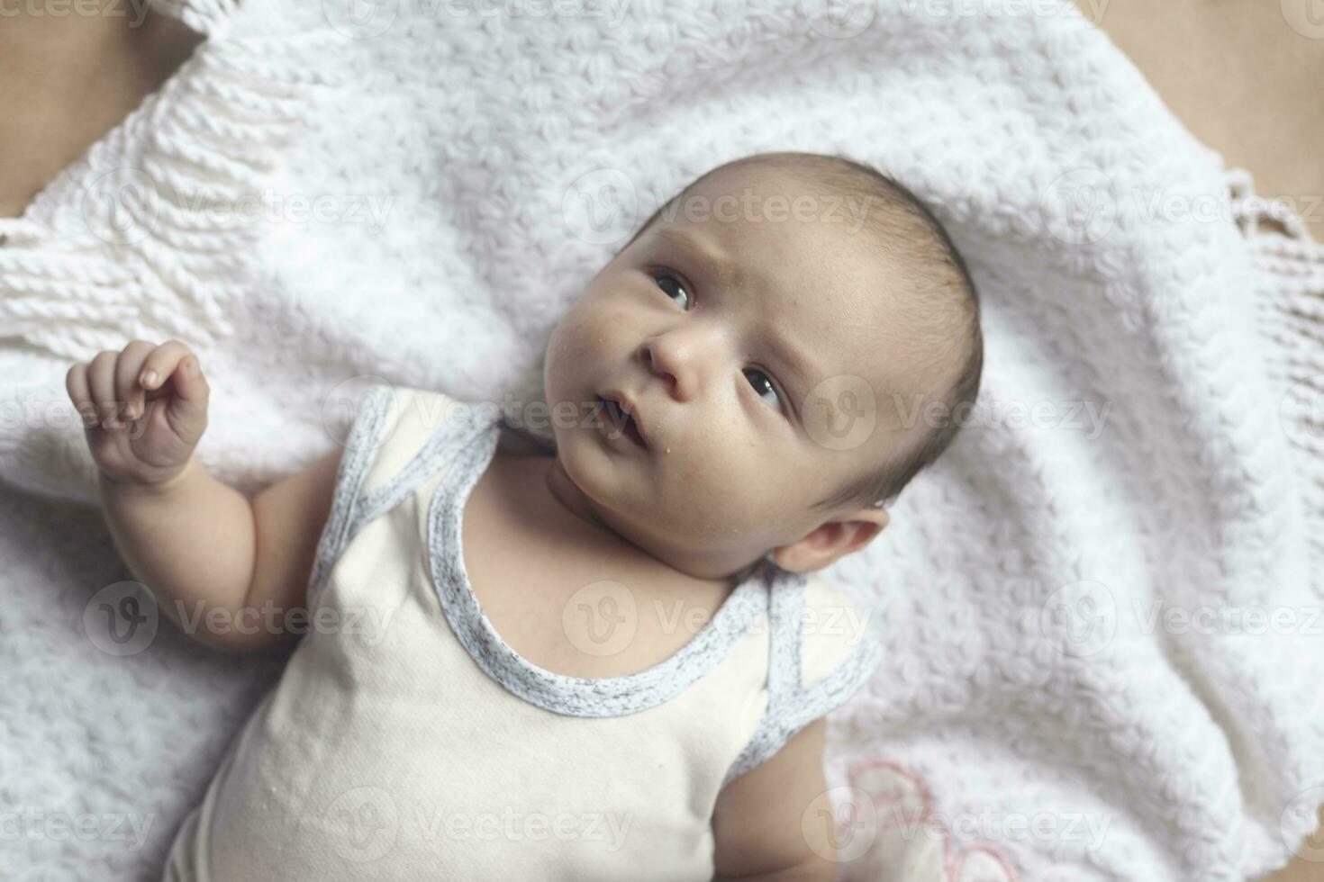 2 mês bebê Garoto mentindo. fechar-se do adorável fofa recém-nascido bebê Garoto do dois meses em suave têxtil. adorável criança jogando foto