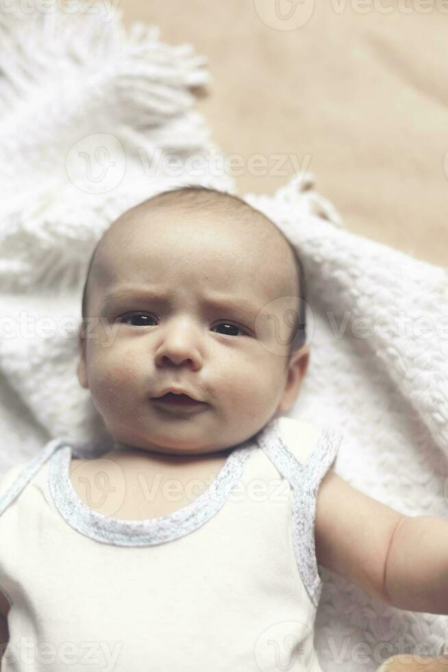 2 mês bebê Garoto mentindo. fechar-se do adorável fofa recém-nascido bebê Garoto do dois meses em suave têxtil. adorável criança jogando foto