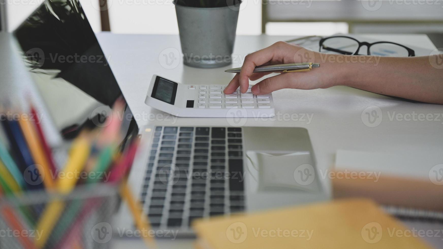 mãos usando calculadora com laptop na frente, conceitos de negócios. foto