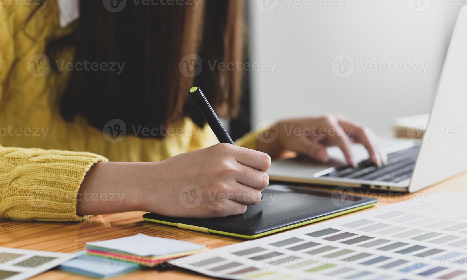 designer feminina desenhando em um tablet gráfico digital. foto