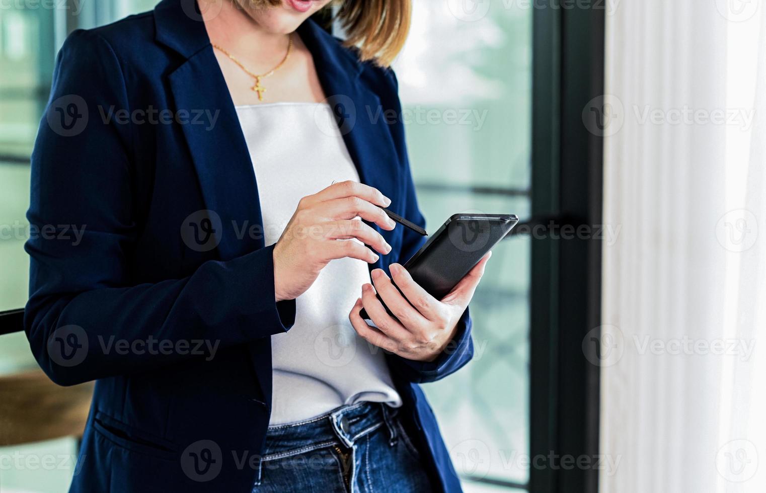 mulheres de negócios entregam com lápis usando no smartphone. foto