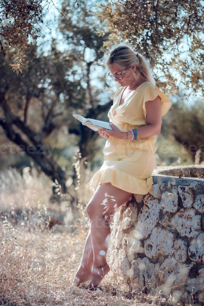 uma mulher loira descalça em um vestido de verão amarelo foto