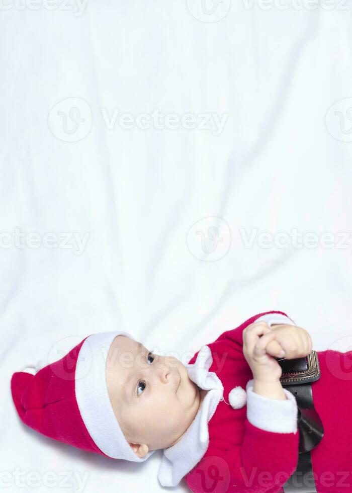 pequeno papai noel. 6-9 meses velho bebê Garoto dentro santa claus fantasia. alegre Natal foto