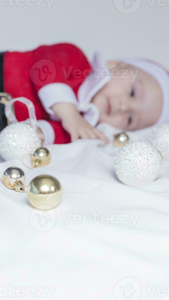 pequeno papai noel. 6-9 meses velho bebê Garoto dentro santa claus fantasia. alegre Natal foto