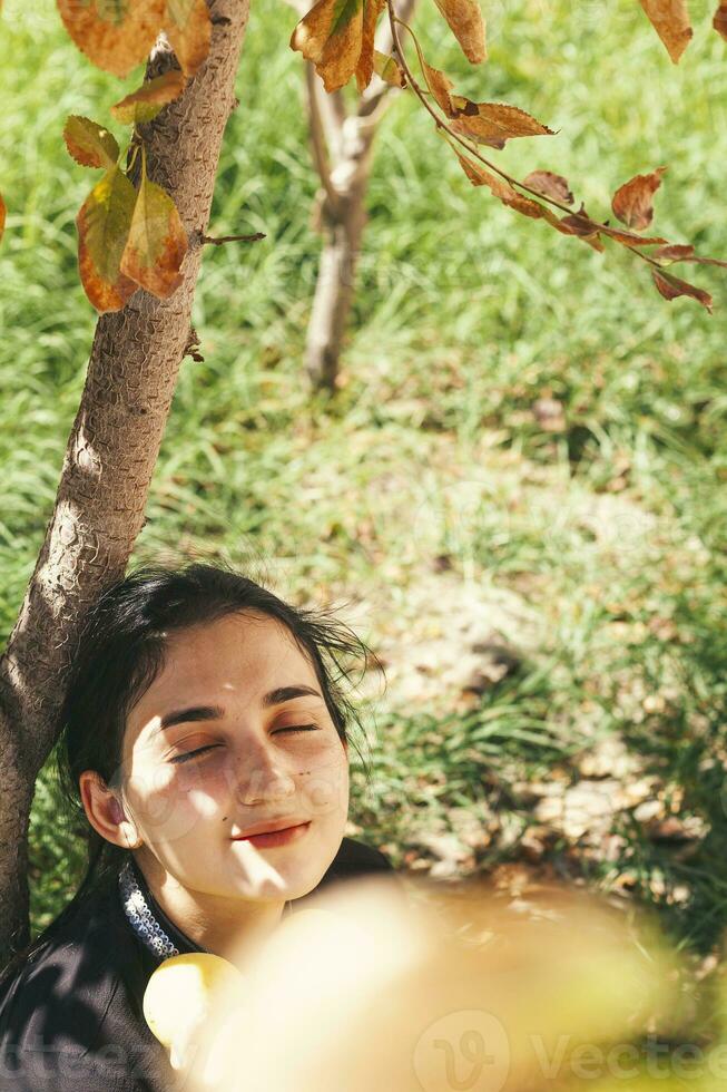 outono retrato. retrato do lindo Oriente médio mulher às maçã jardim. jovem fêmea posando às a natureza com recentemente escolhido outono maçã frutas. maçã mulher foto