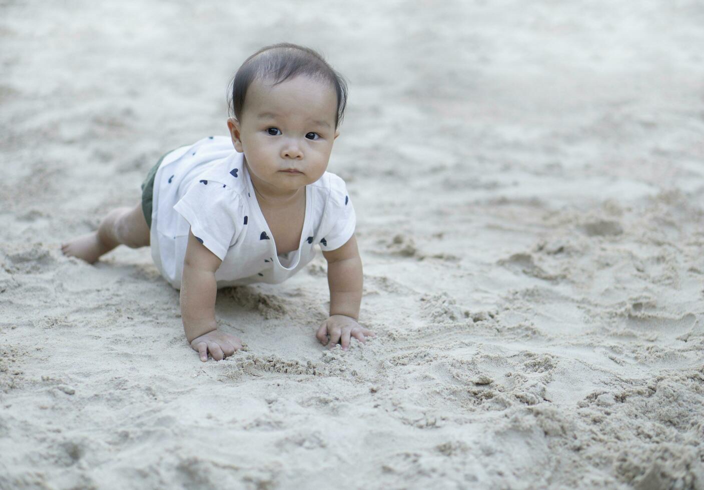 ásia criança pequena bebê tailandês menina jogando com areia foto