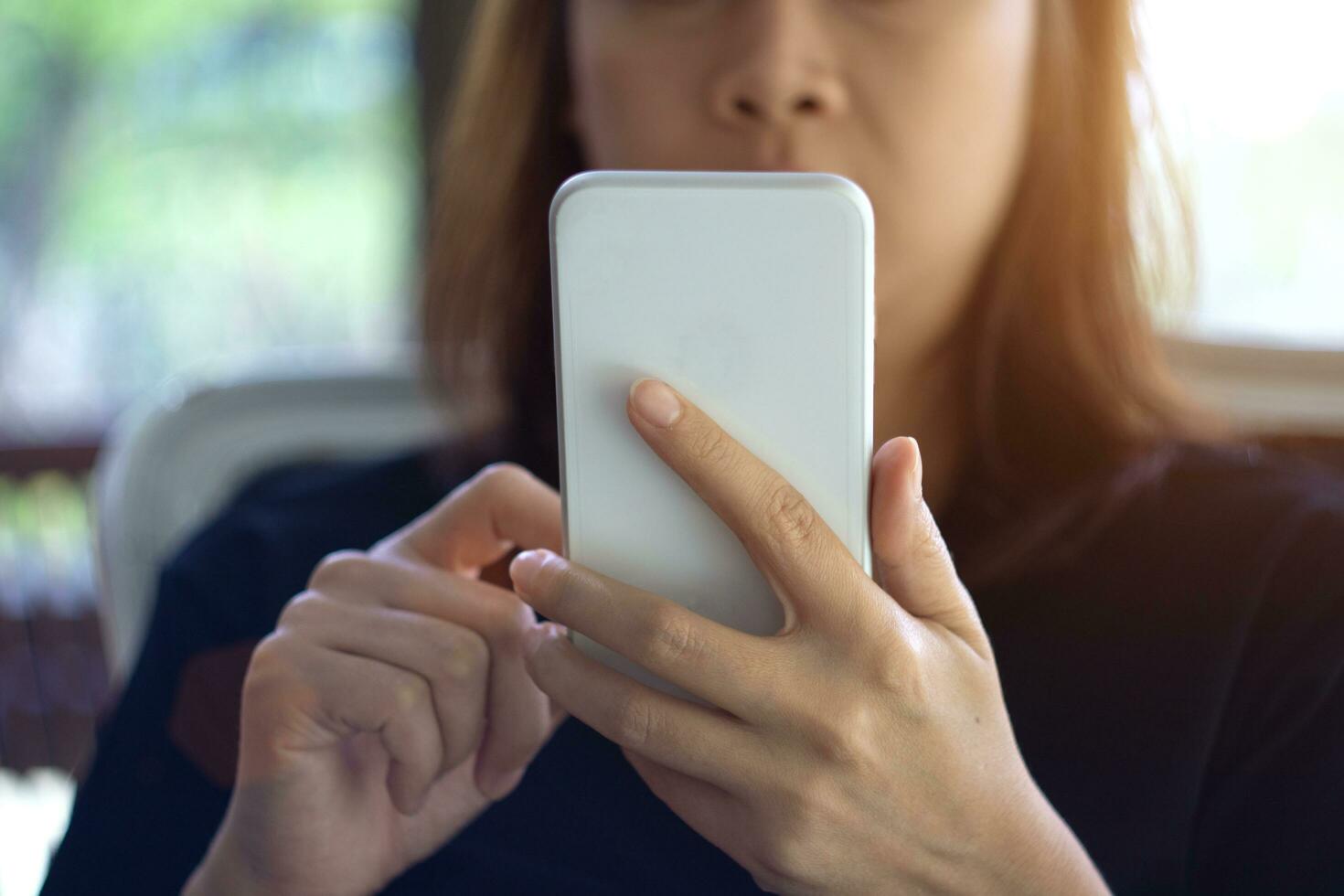 foco mão do jovem ásia mulher tocante Smartphone foto