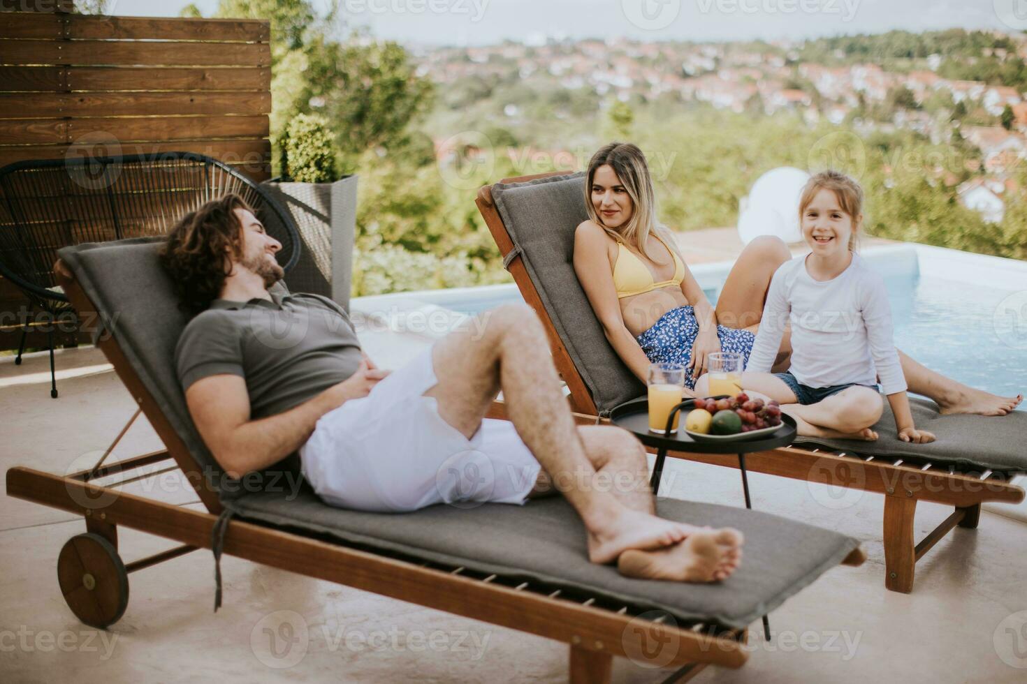 jovem família relaxante de a natação piscina dentro a casa quintal foto