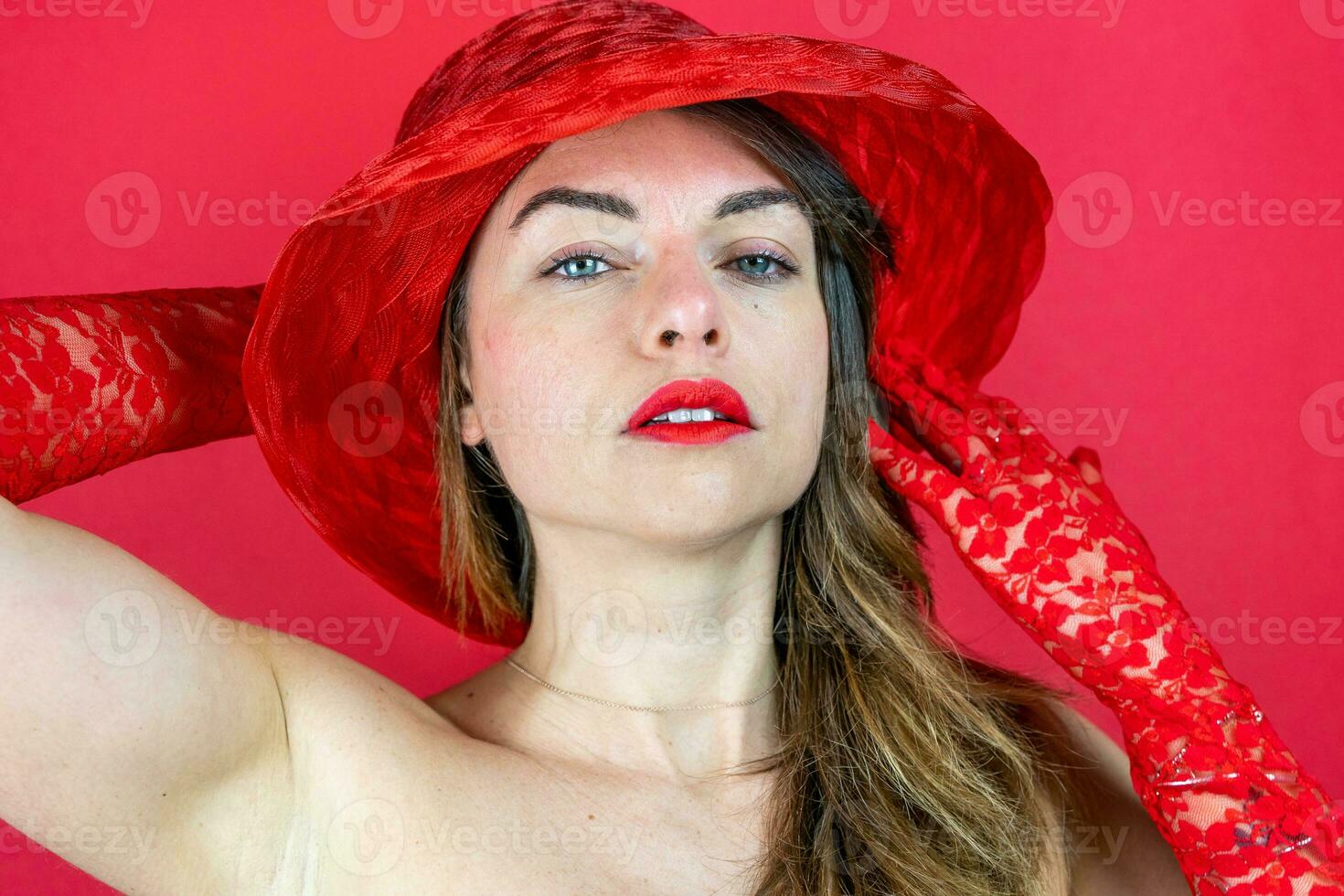 retrato do fofa jovem mulher vestindo chapéu e vermelho luvas em vermelho fundo foto