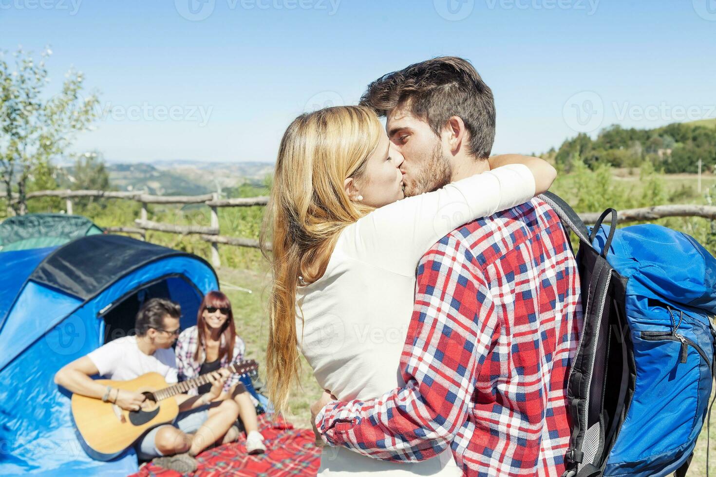 jovem casal se beijando dentro uma acampamento do a Colina foto