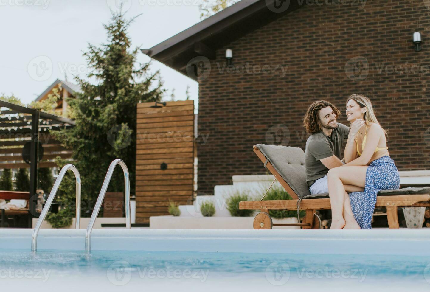 jovem casal relaxante de a natação piscina dentro a casa quintal foto