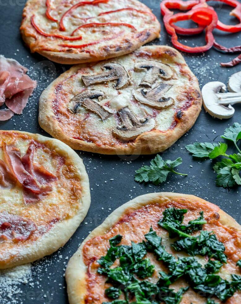 mini pizzas com várias coberturas na placa de madeira foto