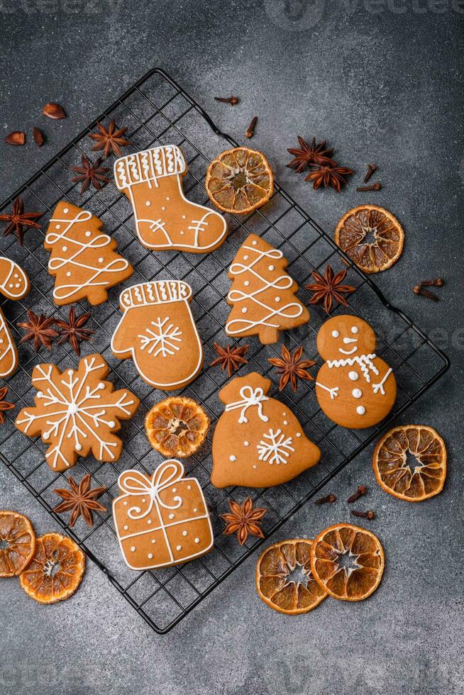 lindo delicioso doce inverno Natal Pão de gengibre biscoitos em uma cinzento texturizado fundo foto