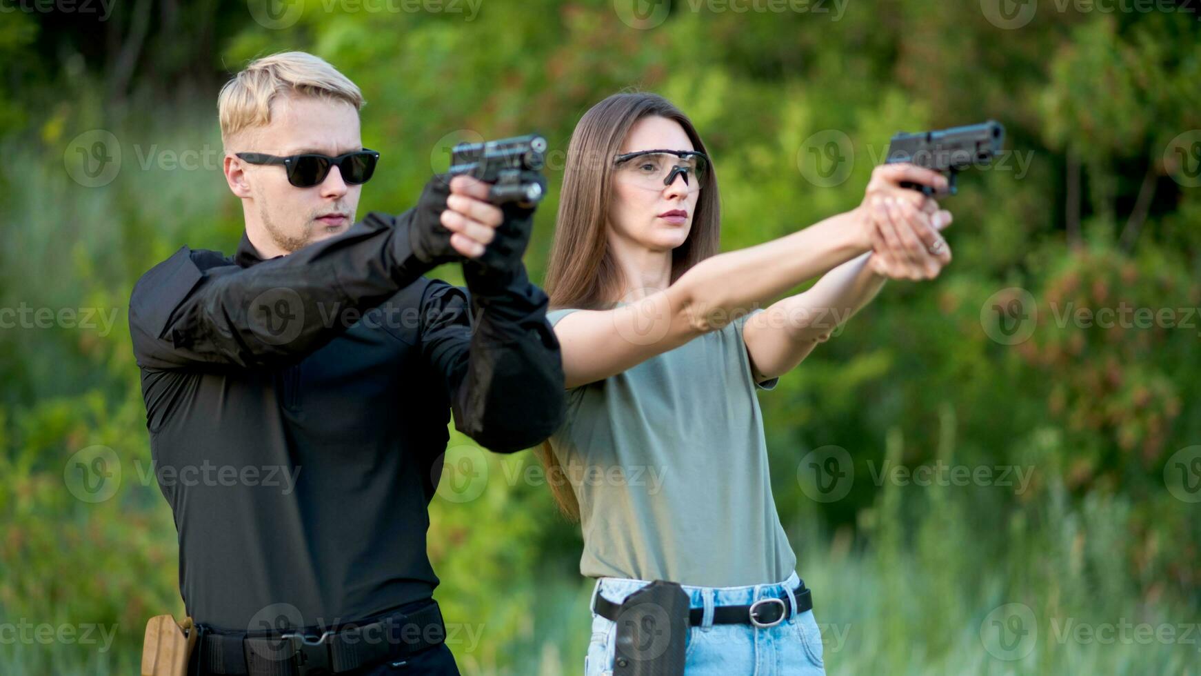 a instrutor ensina a menina para tiro uma pistola às a alcance foto