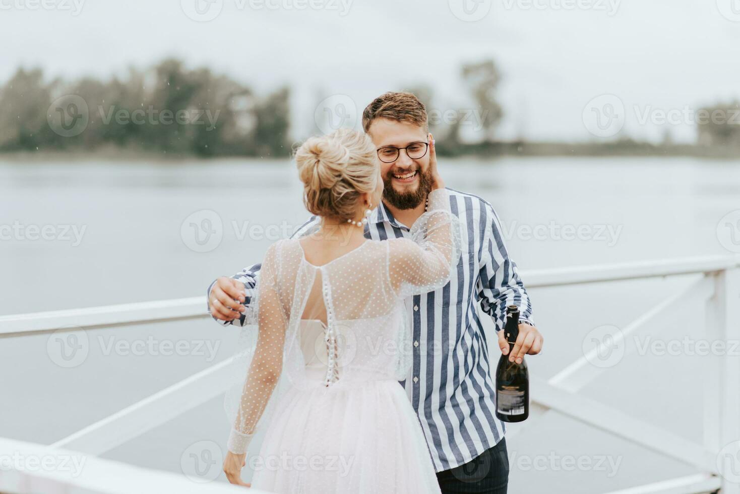 jovem recém-casados abraçando em a cais de a água. foto