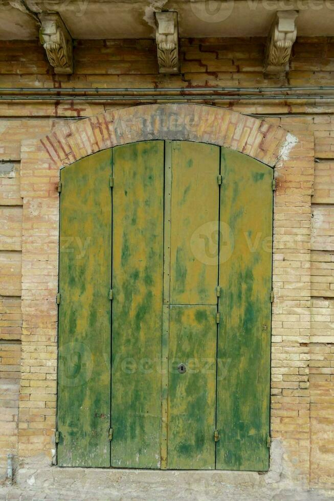 velho verde portas dentro uma tijolo construção foto