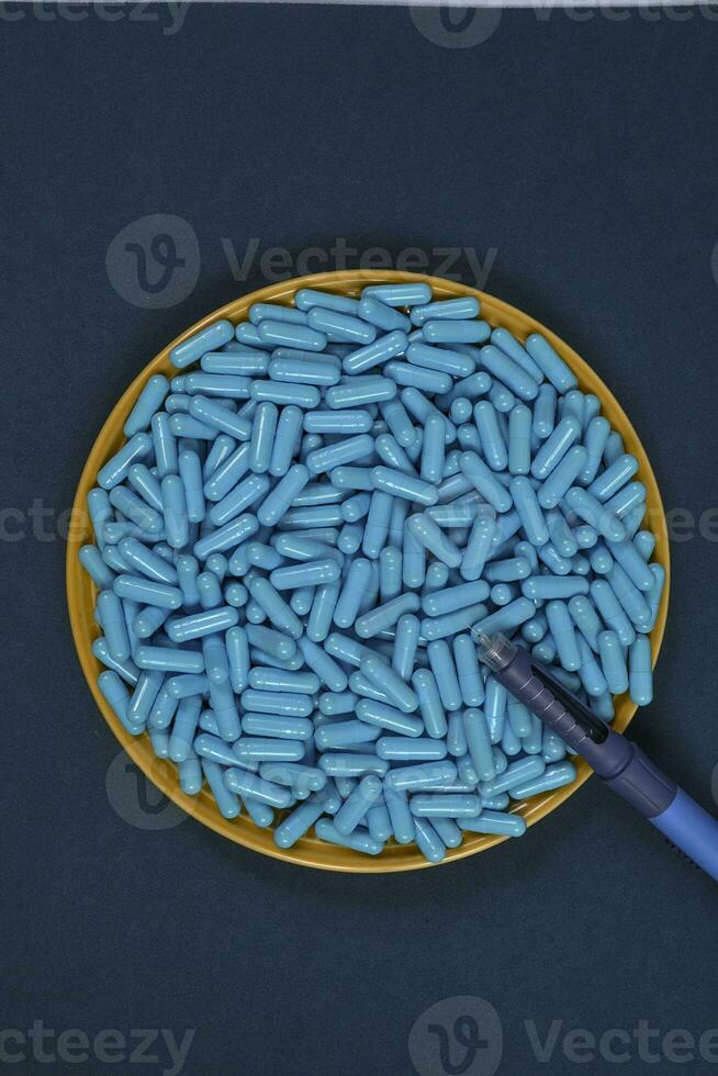amarelo prato cheio do azul remédio cápsulas representando droga overdose foto