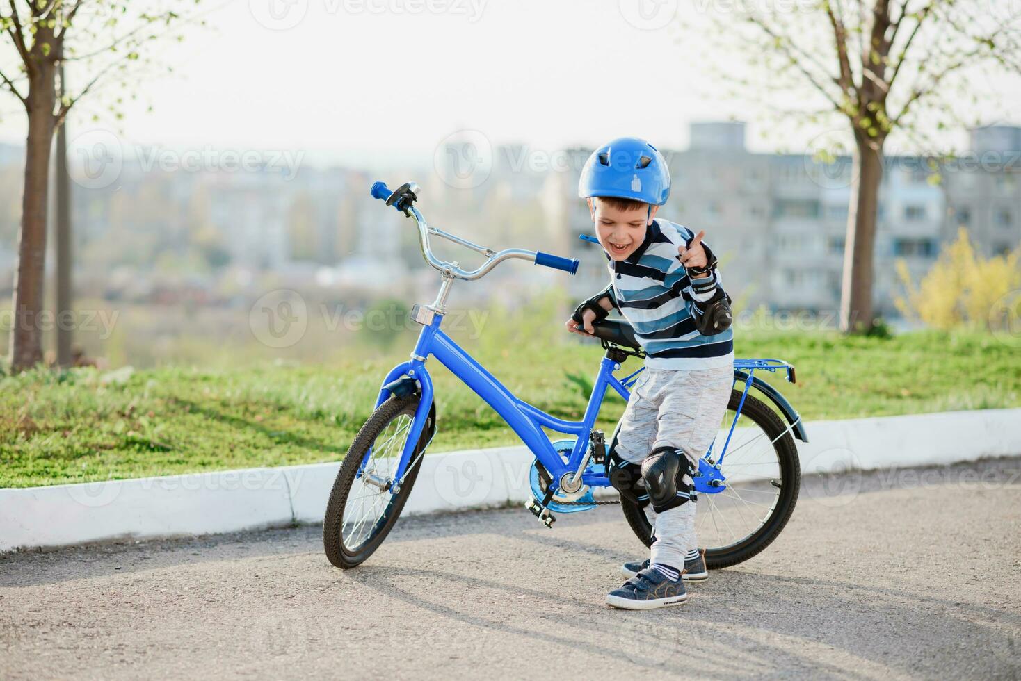 fofa criança dentro capacete e proteção carrinhos perto dele bicicleta foto