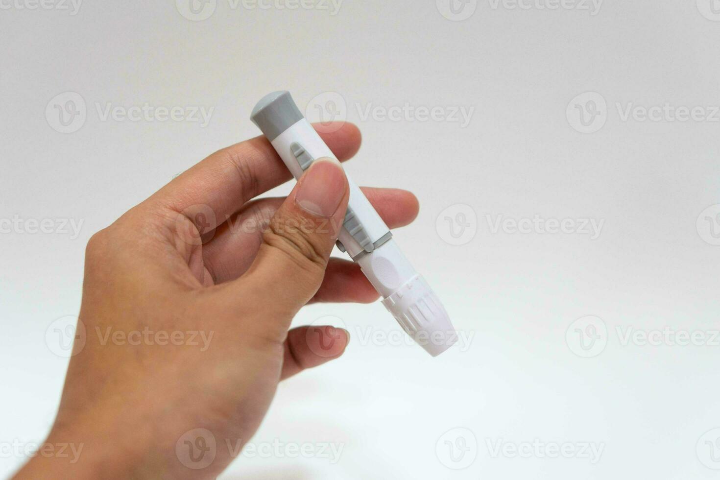 fêmea mão com lanceta caneta em branco fundo. diabetes conceito foto
