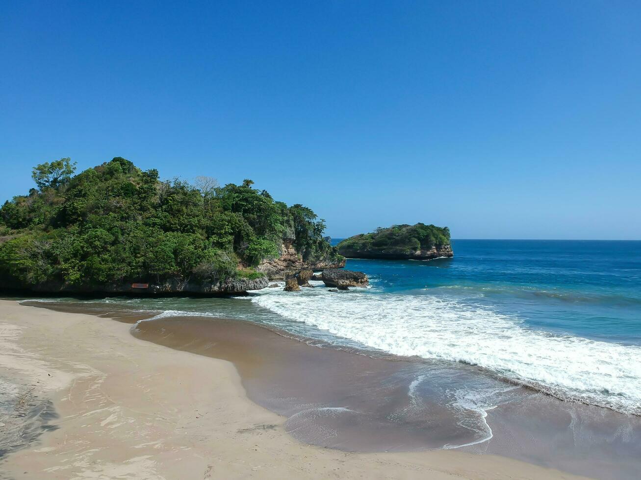 ungapan de praia é dentro leste Java, Indonésia, alongar do de praia areia, ondas e Visualizações do colinas e falésias foto