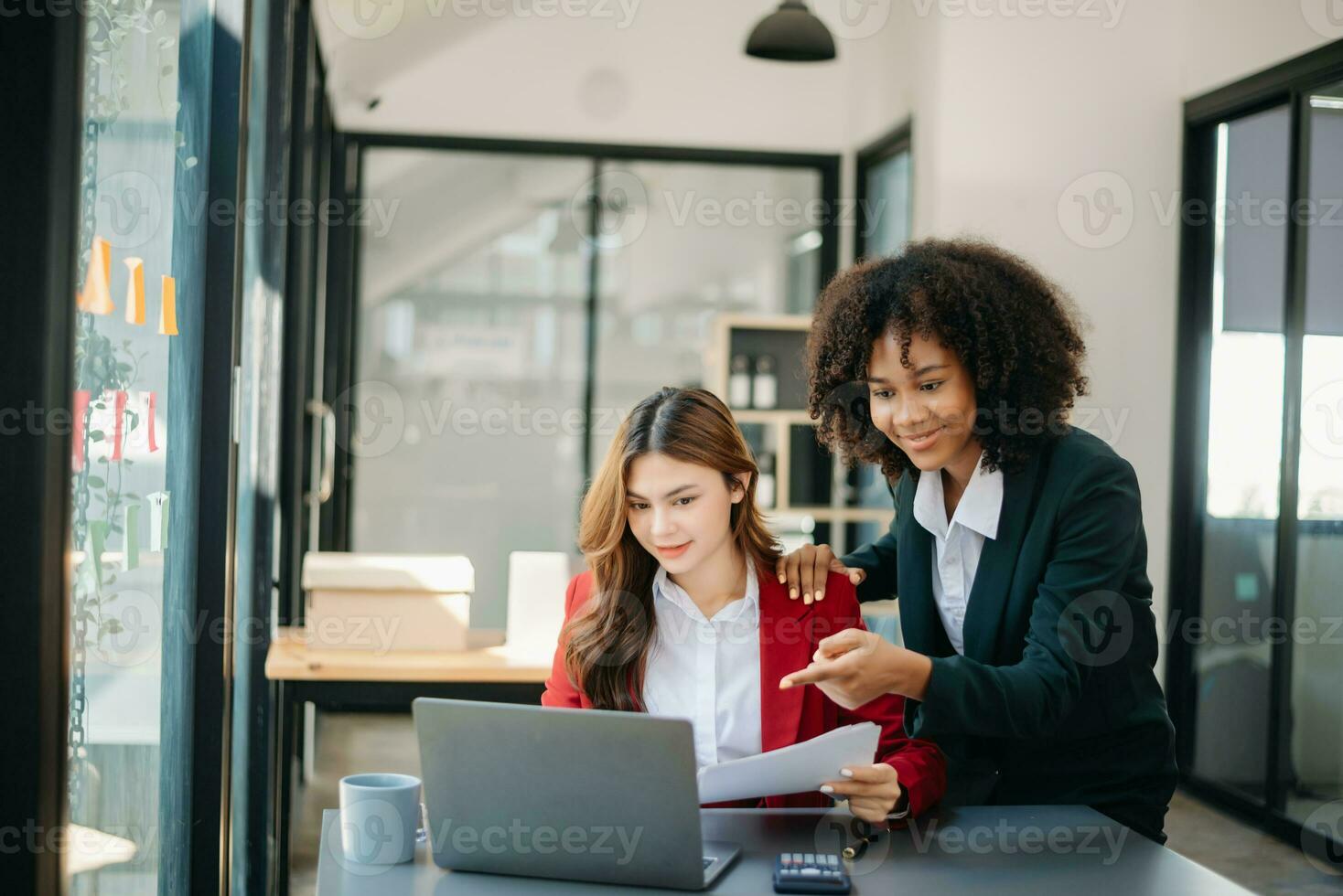 dois o negócio trabalhadores falando em a Smartphone e usando computador portátil às a escritório. foto