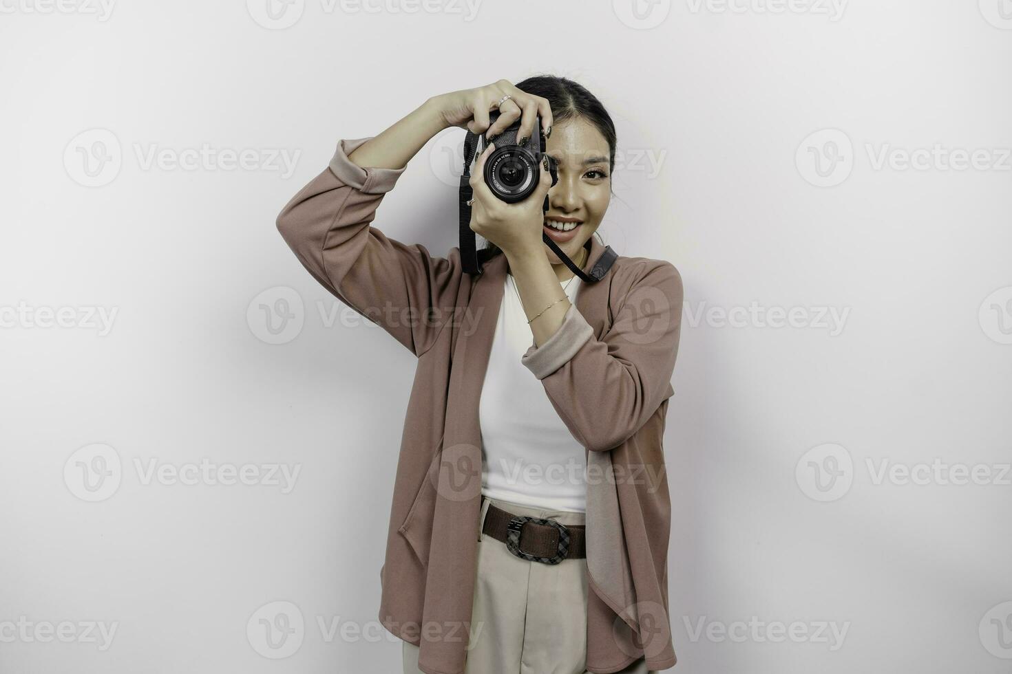 feliz sorridente jovem ásia mulher turista em pé com Câmera levando foto isolado em branco estúdio fundo