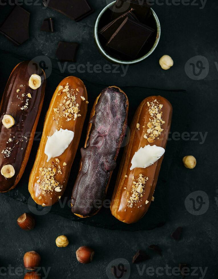 doce chocolate eclairs em Preto de madeira borda foto