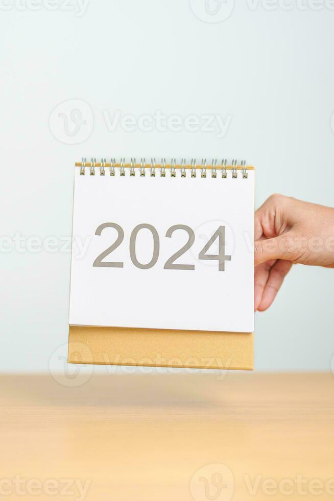 2024 ano calendário em mesa fundo. feliz Novo ano, resolução, metas, plano, Ação, missão e financeiro conceito foto