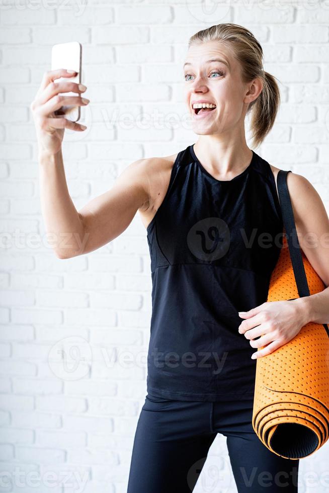 jovem sorridente fitness fazendo selfie após o treino foto