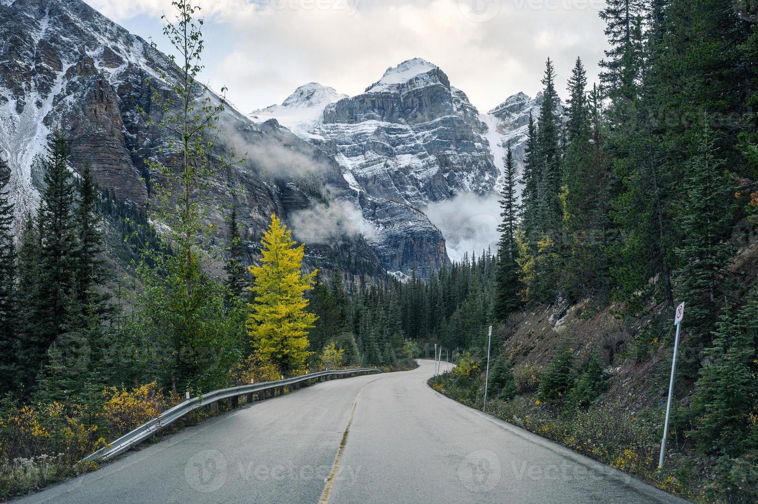 dirigindo na rodovia com montanhas rochosas na floresta de outono no Lago Moraine, Alberta foto