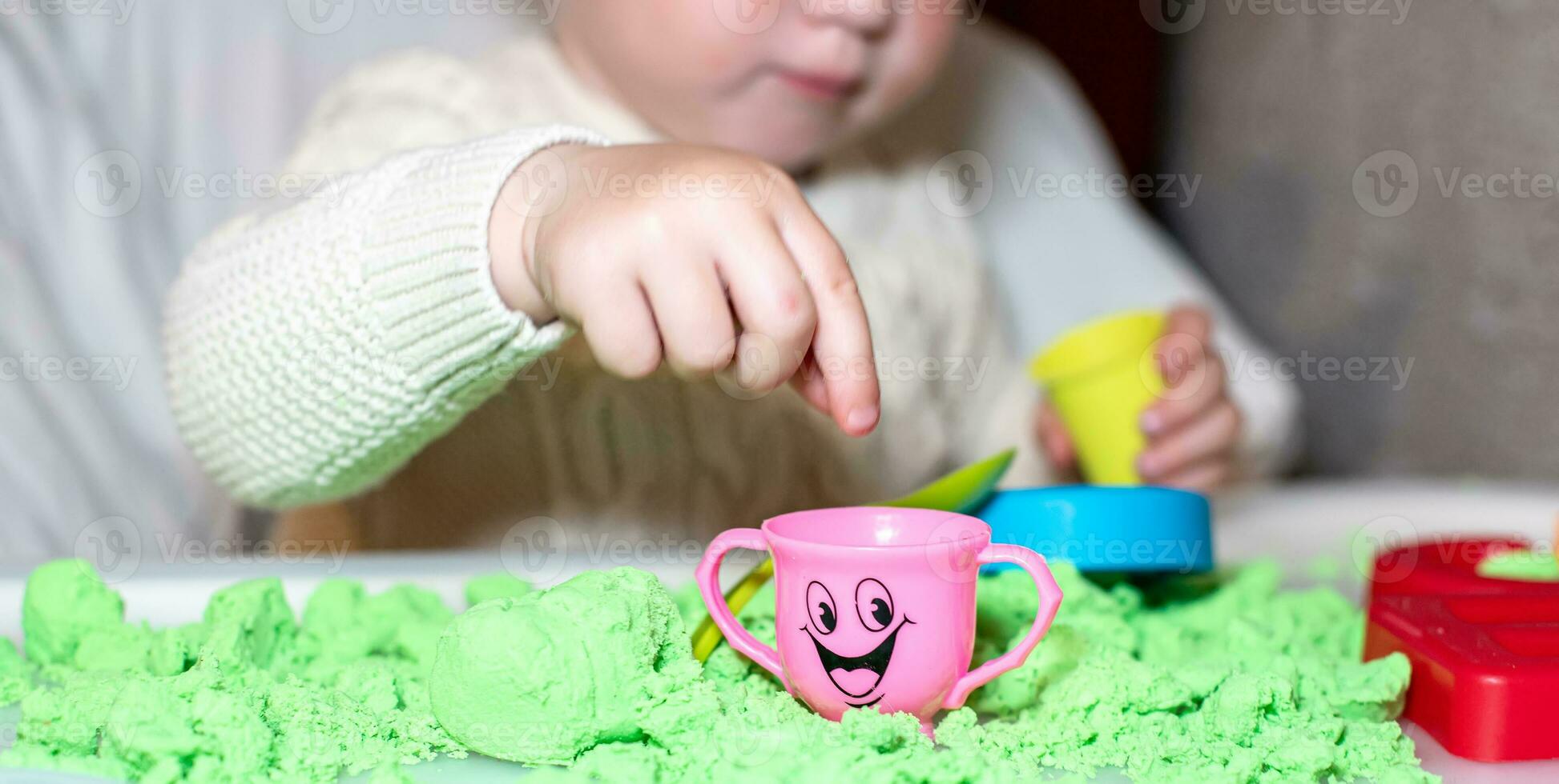 bebê detém mofo para jogando com areia às lar. educacional brinquedos para crianças acima para ano. menina tocam com cinética areia. criança constrói pastores dentro Formato do cartas do areia. cedo desenvolvimento do crianças. foto