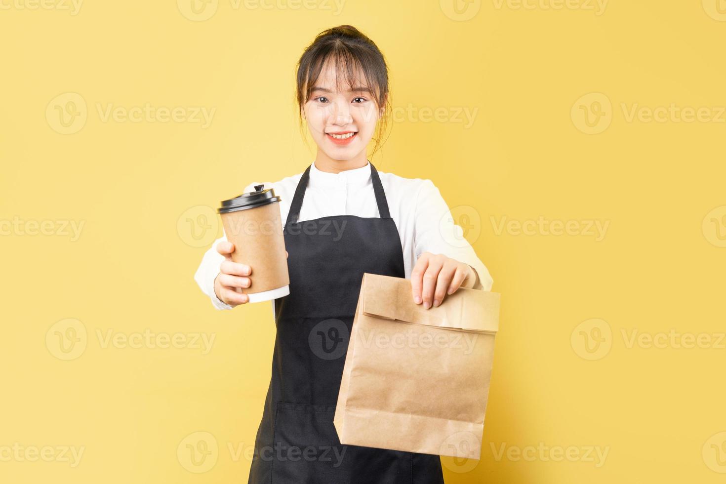 retrato de garçonete alegre em fundo amarelo foto