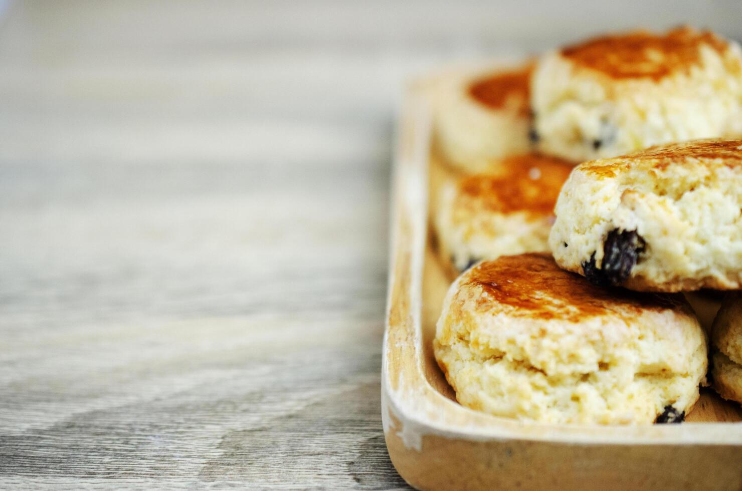 close up de scone passas caseiro em fundos de mesa de madeira foto