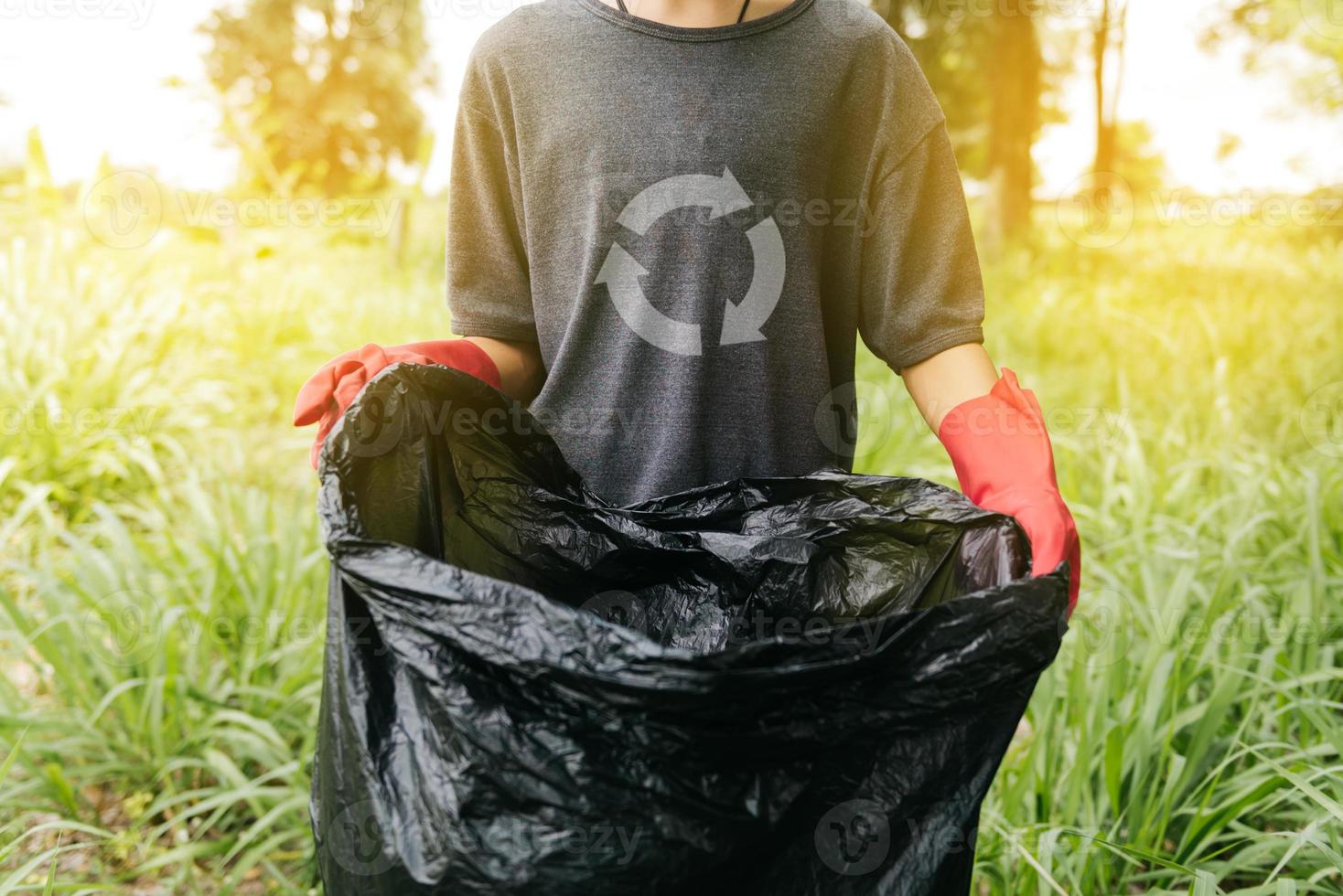 menino homem mão pegar uma garrafa de plástico na floresta. conceito de ambiente. foto