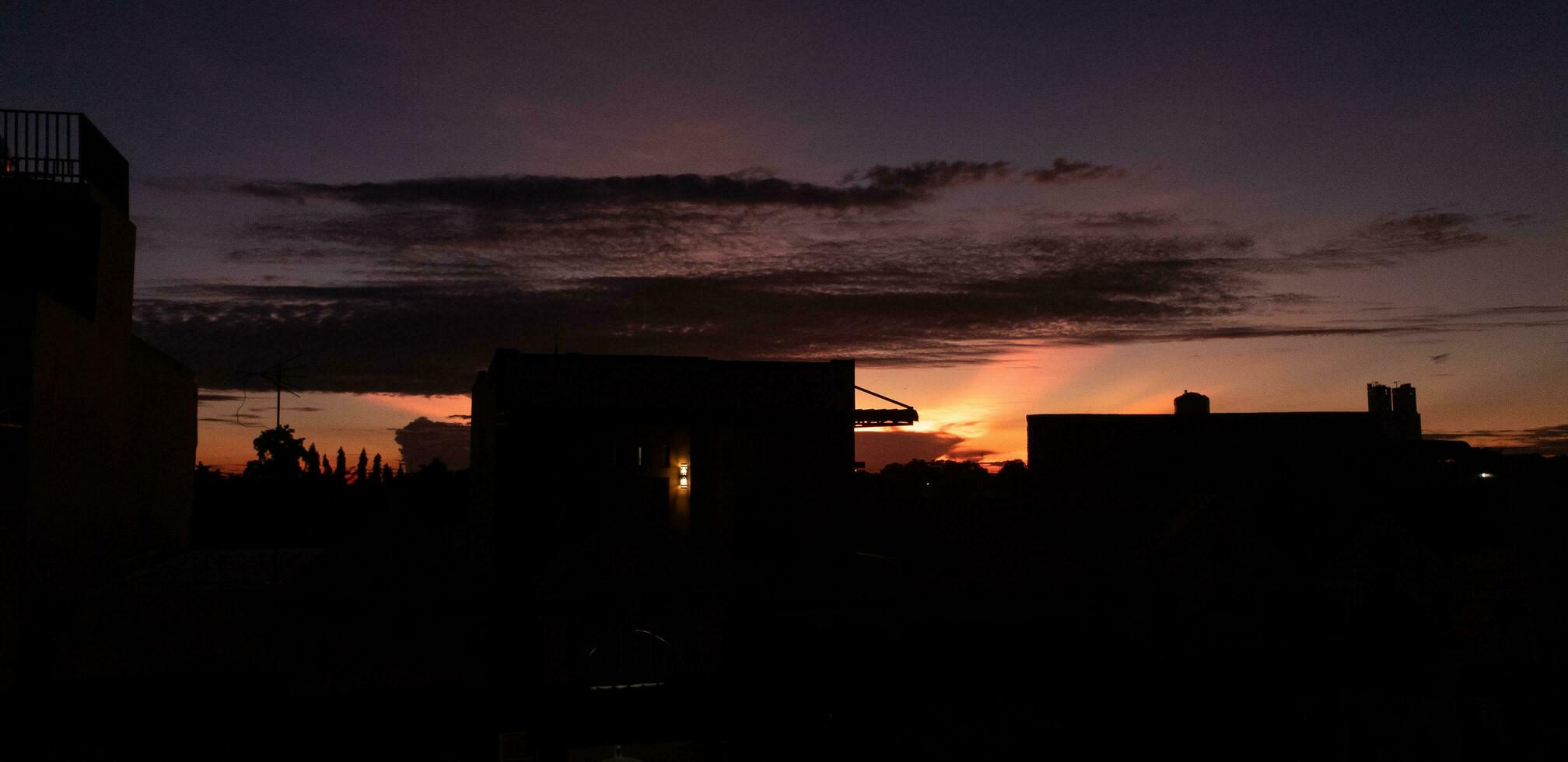 construção silhueta às pôr do sol tempo. colorida laranja-rosa nuvem céu. foto