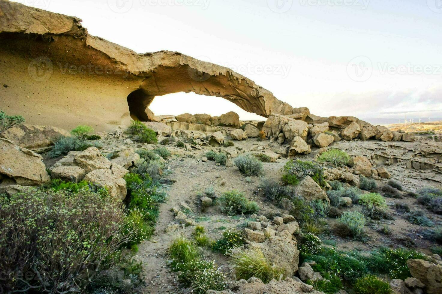 uma Rocha formação dentro a deserto com uma caverna foto