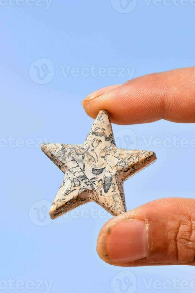 uma mão segurando uma Estrela em forma pedra foto