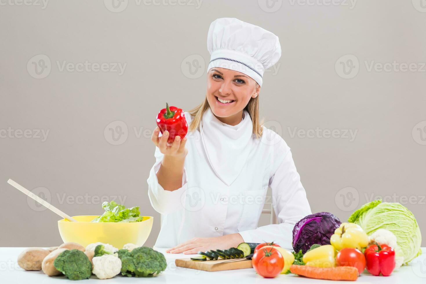 fêmea chefe de cozinha mostrando Pimenta enquanto fazer saudável refeição foto