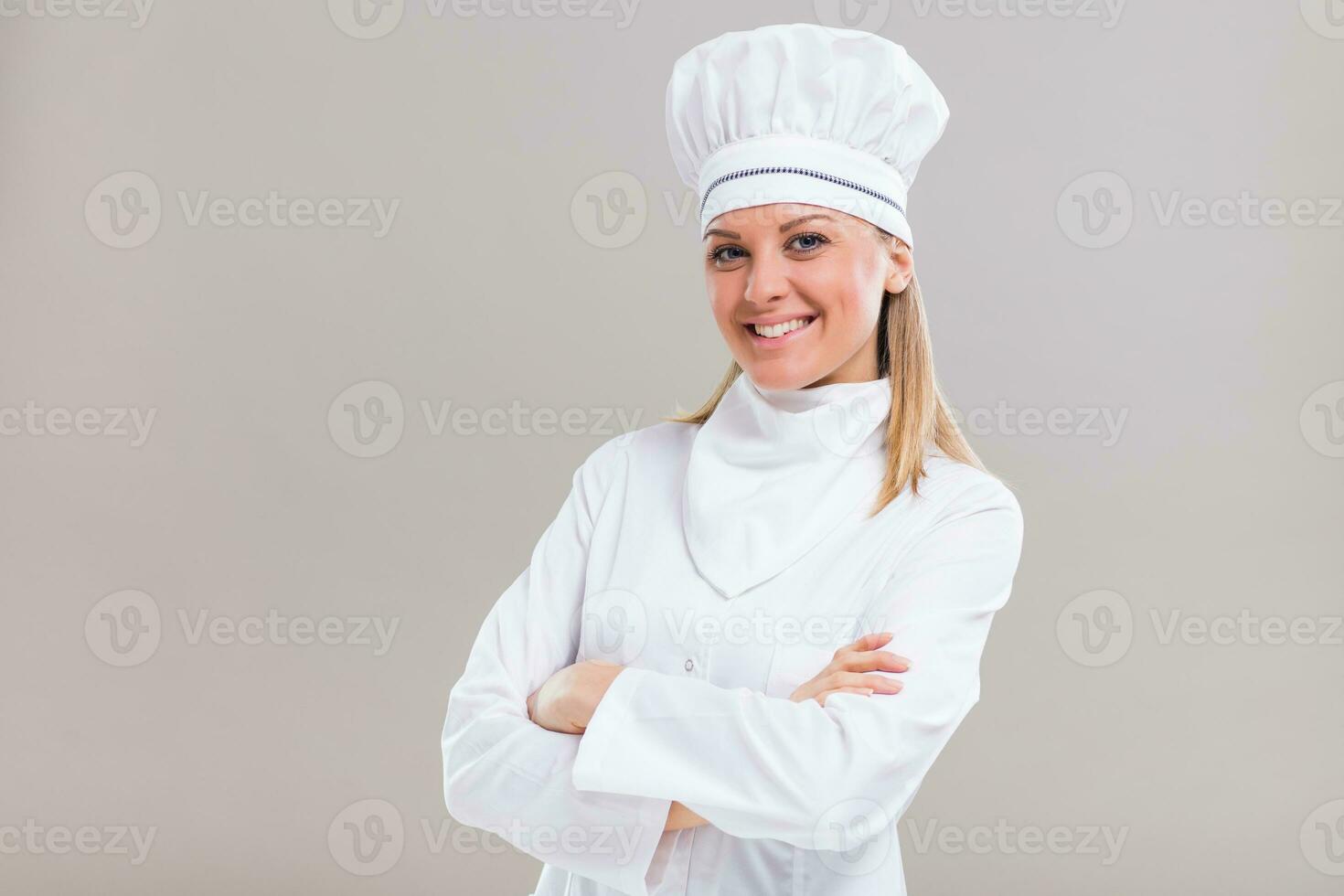 retrato do lindo fêmea chefe de cozinha em cinzento fundo. foto