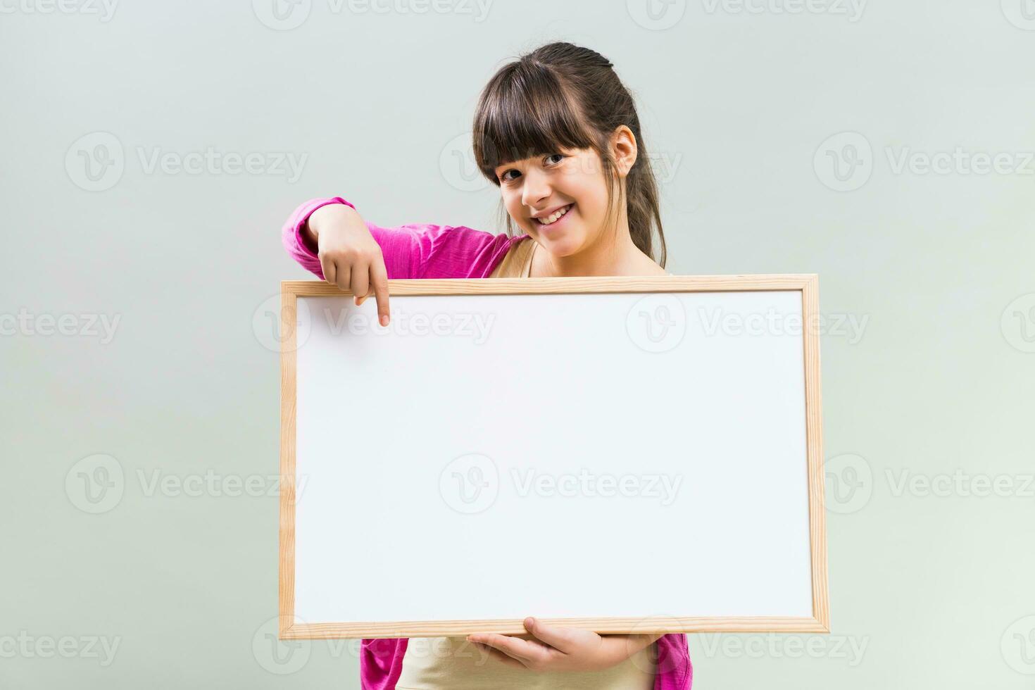 pequeno menina segurando quadro branco foto