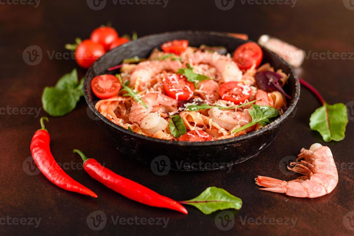 macarrão saboroso com camarão e tomate na frigideira foto