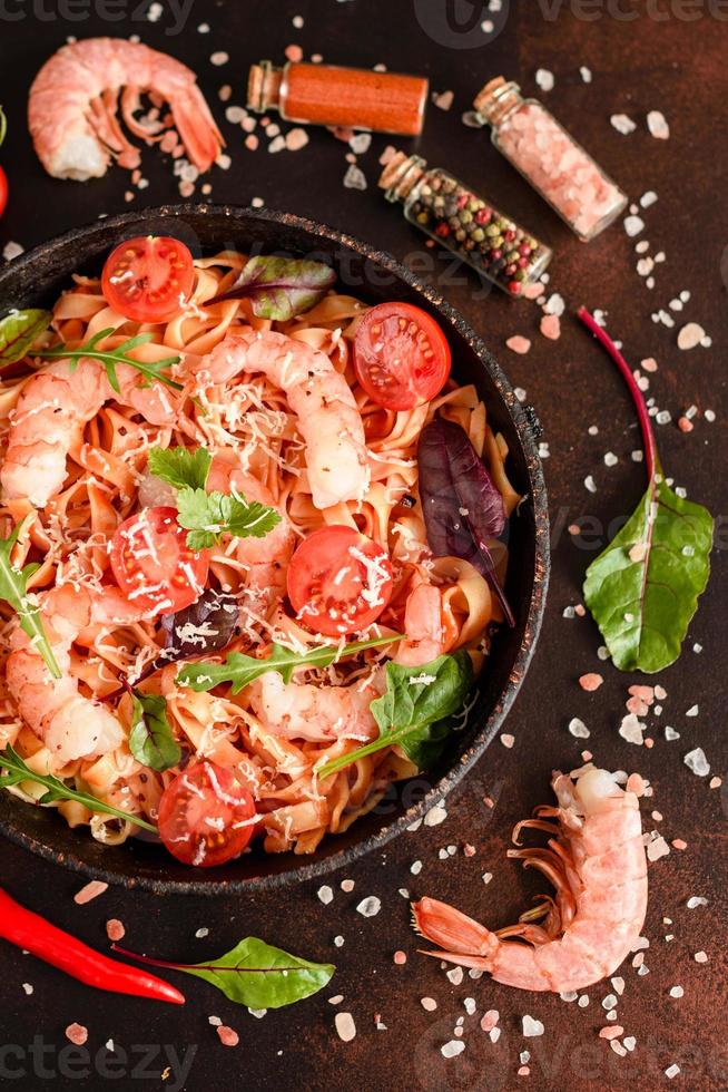 macarrão saboroso com camarão e tomate na frigideira foto