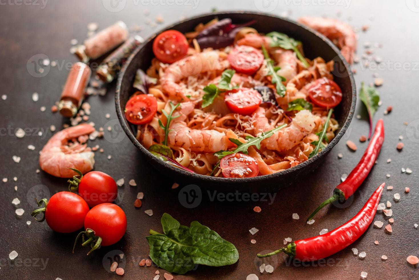 macarrão saboroso com camarão e tomate na frigideira foto