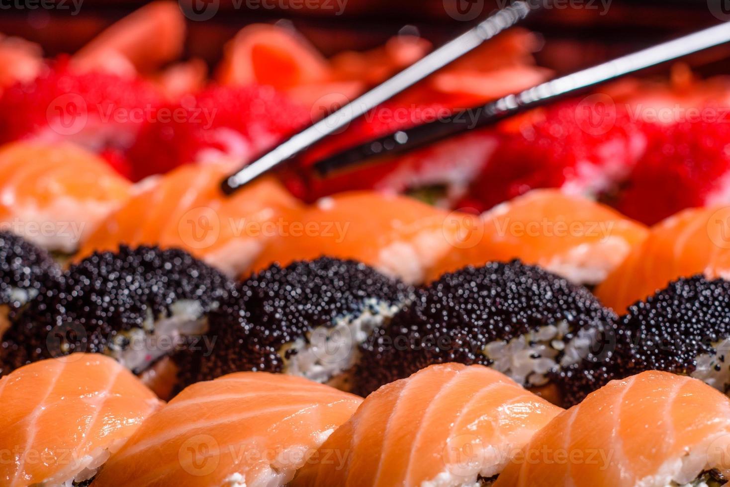 vários tipos de sushi servidos em fundo escuro foto