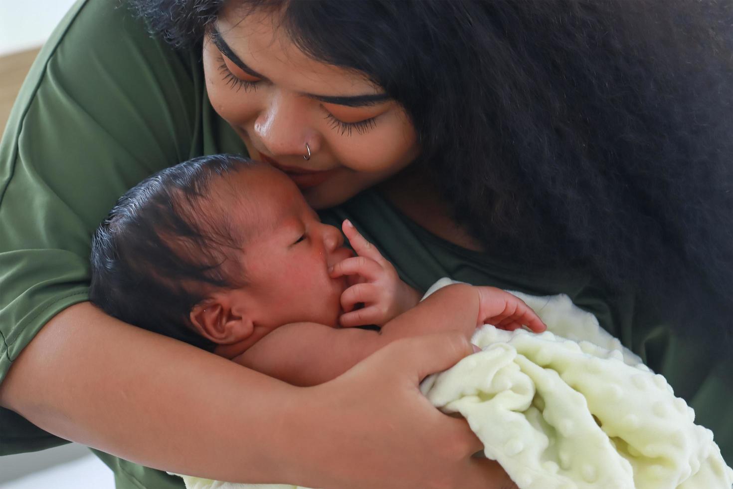 mãe gostava de brincar com seu filho recém-nascido feliz, mãe segurando e beijando seu filho. o conceito de amor e laços familiares foto