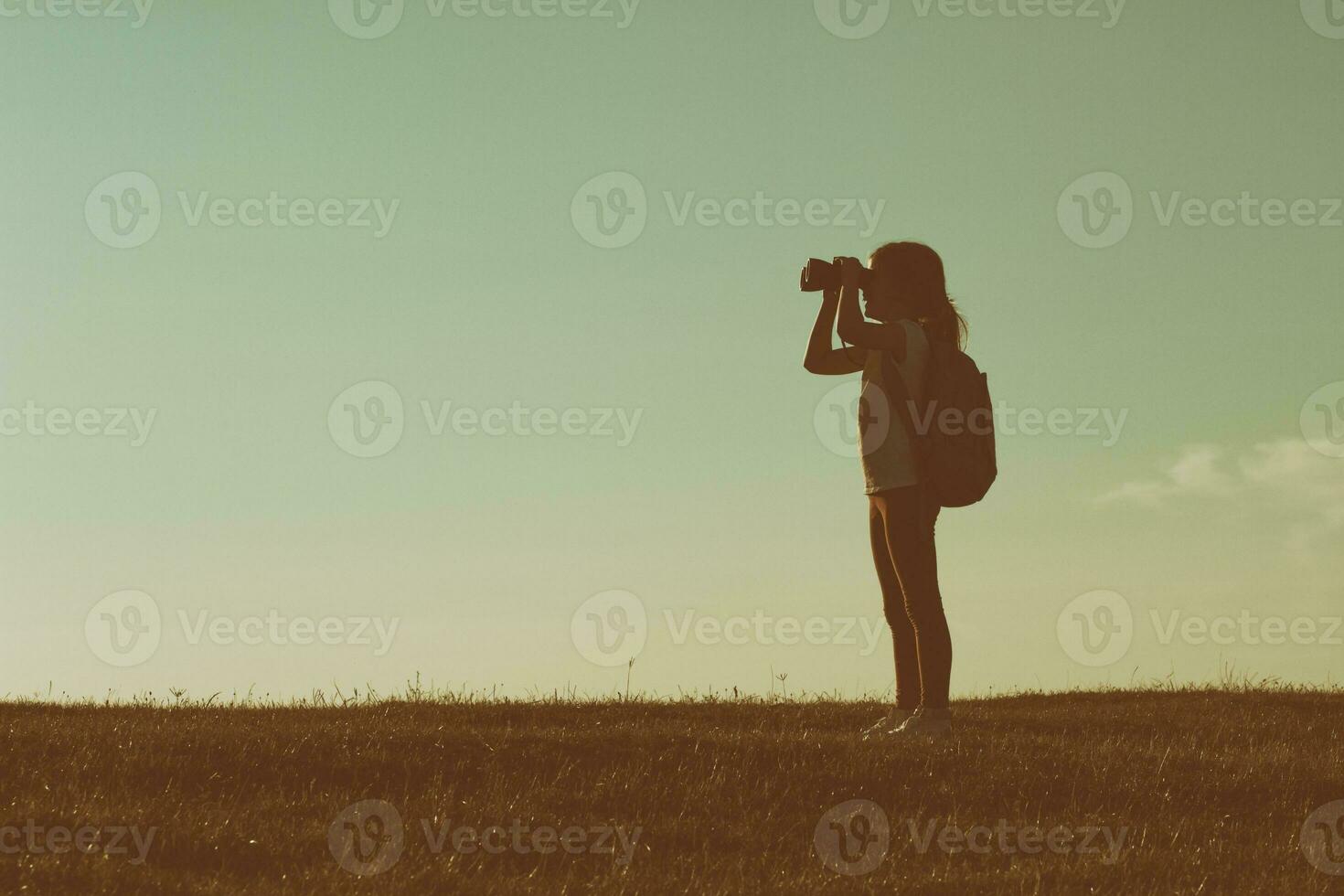 pequeno menina caminhante com binóculos foto