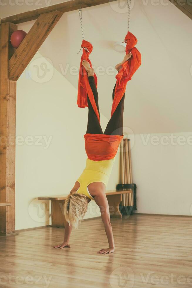 mulher fazendo aéreo ioga dentro a ginástica estúdio foto